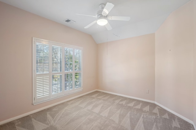 empty room with visible vents, baseboards, lofted ceiling, ceiling fan, and light colored carpet