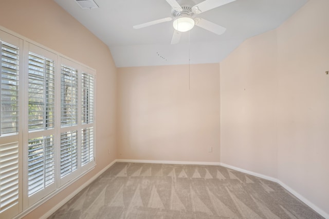 empty room with visible vents, ceiling fan, baseboards, lofted ceiling, and light carpet