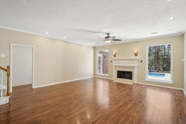 unfurnished living room featuring a high end fireplace, baseboards, ceiling fan, hardwood / wood-style flooring, and a textured ceiling