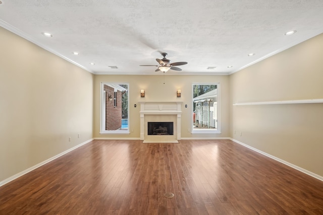 unfurnished living room featuring baseboards, a fireplace with flush hearth, hardwood / wood-style floors, and a ceiling fan