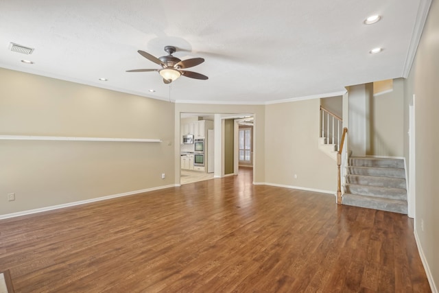 unfurnished living room featuring wood finished floors, a ceiling fan, visible vents, baseboards, and stairs