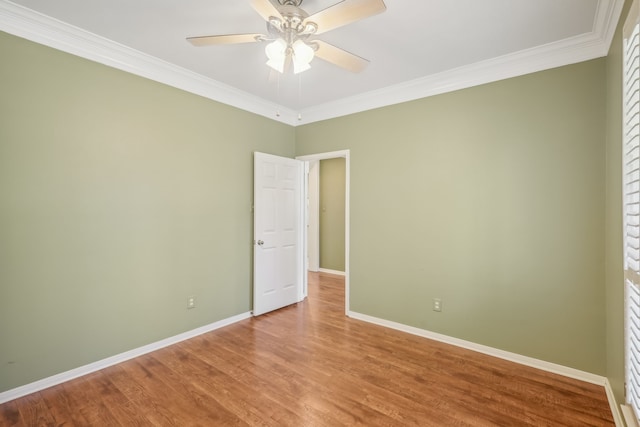 spare room featuring ornamental molding, ceiling fan, baseboards, and wood finished floors