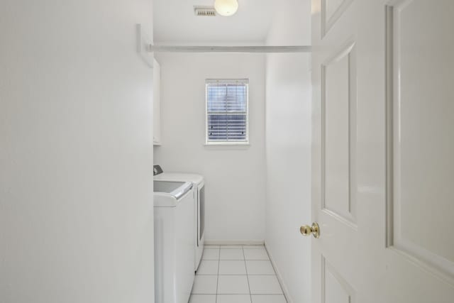 laundry room featuring washing machine and clothes dryer, visible vents, baseboards, light tile patterned floors, and cabinet space