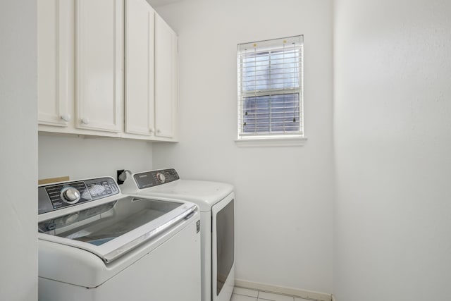 washroom with cabinet space, independent washer and dryer, and baseboards