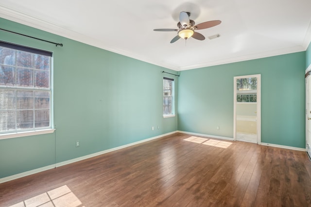 unfurnished room featuring visible vents, ornamental molding, a ceiling fan, hardwood / wood-style flooring, and baseboards