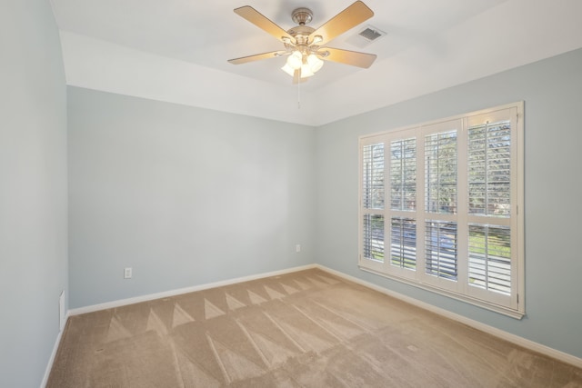 empty room with visible vents, baseboards, light colored carpet, and ceiling fan