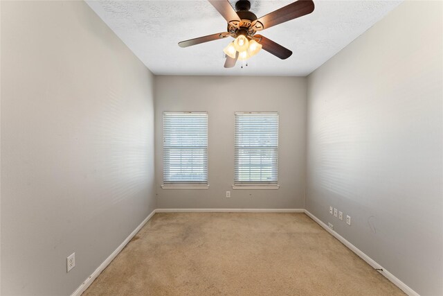 unfurnished room featuring ceiling fan, a textured ceiling, baseboards, and light carpet