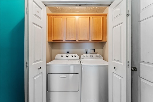 clothes washing area featuring cabinet space and washing machine and dryer