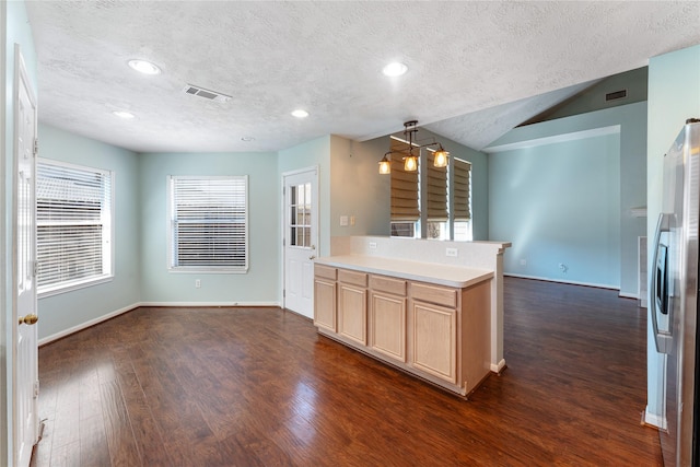 kitchen featuring visible vents, dark wood-style floors, light brown cabinets, and freestanding refrigerator