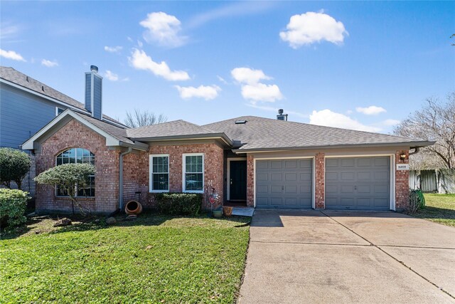 ranch-style house featuring brick siding, a garage, concrete driveway, and a front yard