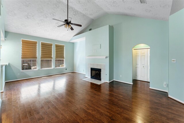 unfurnished living room with ceiling fan, baseboards, wood finished floors, and a tile fireplace