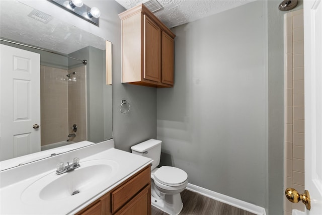 bathroom featuring vanity, wood finished floors, baseboards, a textured ceiling, and toilet