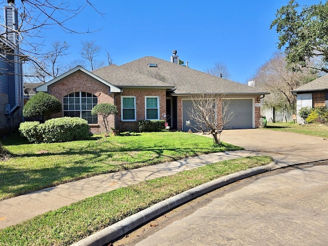 single story home featuring a front yard, driveway, roof with shingles, an attached garage, and brick siding