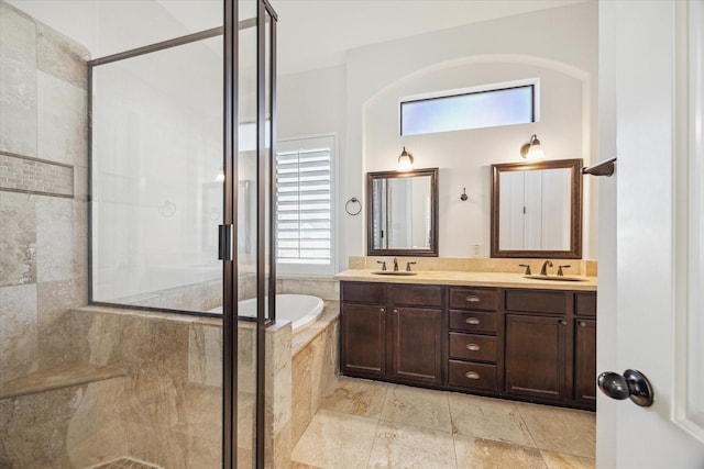 full bath featuring a stall shower, a garden tub, and a sink