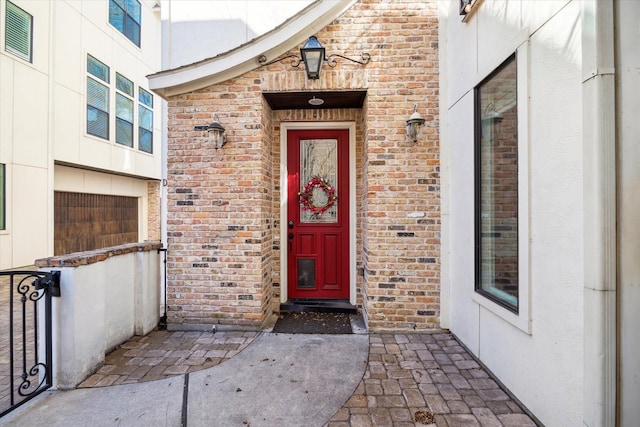 entrance to property featuring brick siding