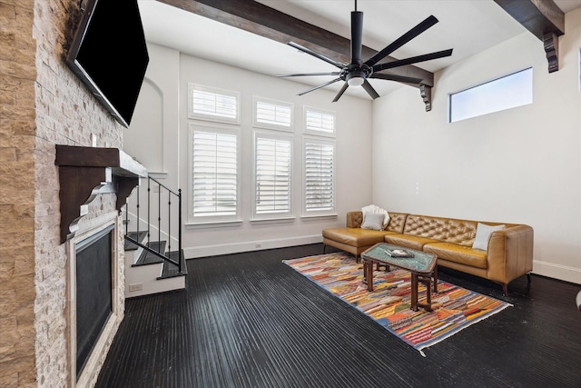 living area featuring a ceiling fan, stairs, baseboards, and beam ceiling