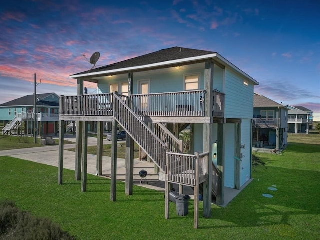 playground at dusk featuring a patio, stairway, and a lawn