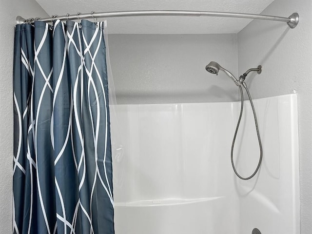 bathroom featuring a textured ceiling and shower / bath combination with curtain