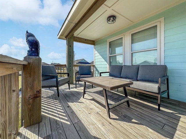 wooden terrace with an outdoor living space