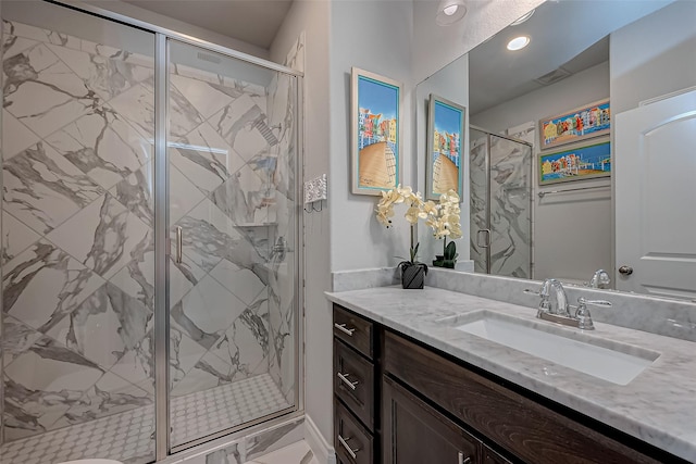 full bath with a marble finish shower, visible vents, and vanity