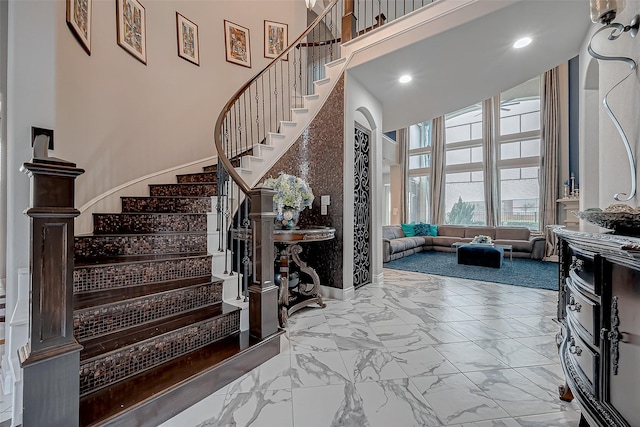 entrance foyer with marble finish floor, recessed lighting, a high ceiling, baseboards, and stairs