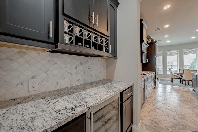 kitchen with light stone counters, beverage cooler, visible vents, and marble finish floor