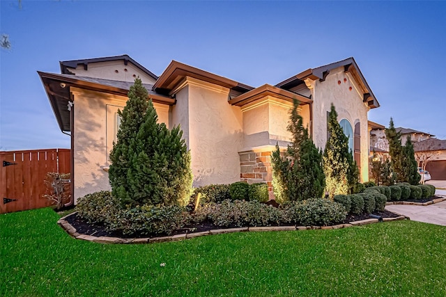 view of home's exterior featuring a yard, fence, and stucco siding