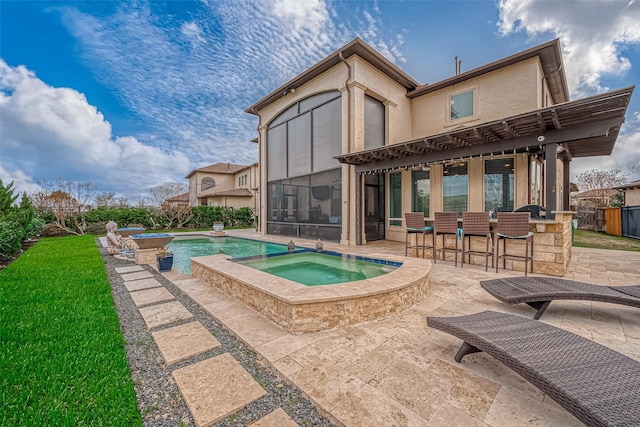 view of pool with a patio area, a pool with connected hot tub, outdoor dry bar, and a sunroom