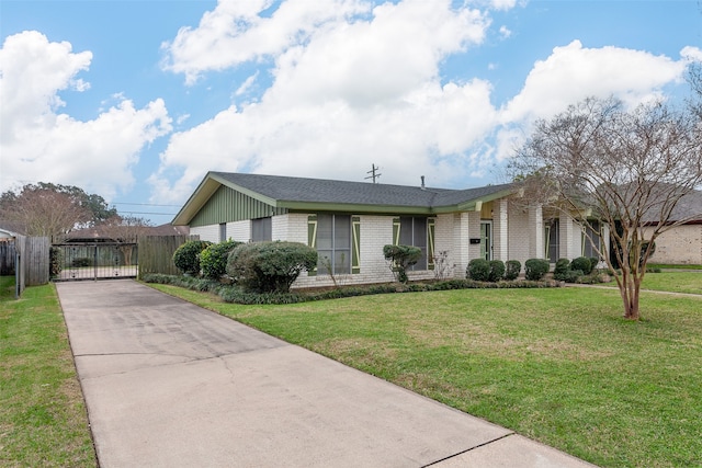 ranch-style house with brick siding, fence, driveway, a gate, and a front yard