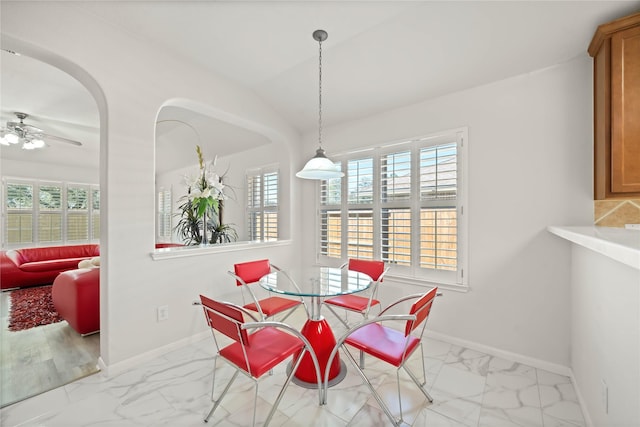 dining room featuring a ceiling fan, marble finish floor, and baseboards