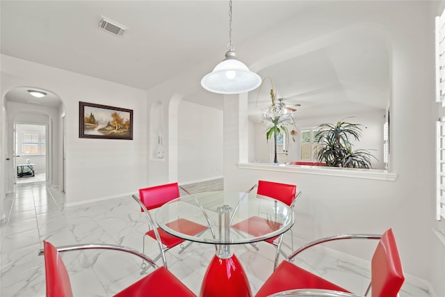 dining space featuring marble finish floor, baseboards, visible vents, and arched walkways