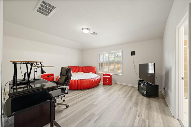 bedroom with baseboards, visible vents, and light wood finished floors