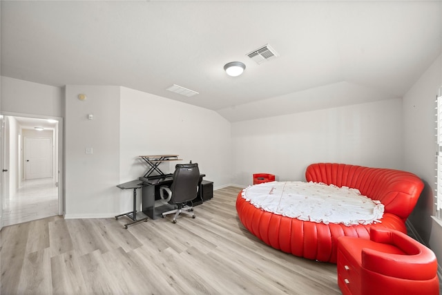 bedroom featuring lofted ceiling, light wood-type flooring, visible vents, and baseboards