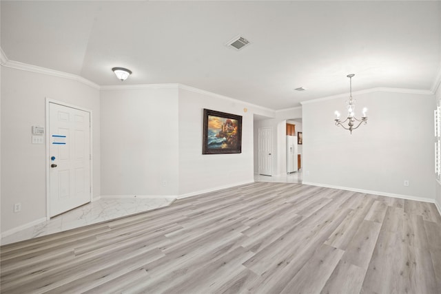 empty room featuring crown molding, a notable chandelier, visible vents, light wood-type flooring, and baseboards