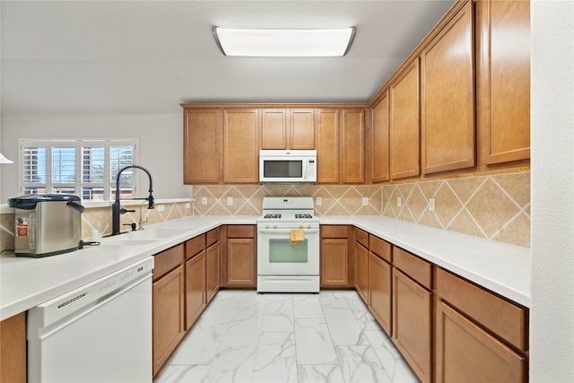 kitchen with marble finish floor, light countertops, brown cabinetry, a sink, and white appliances