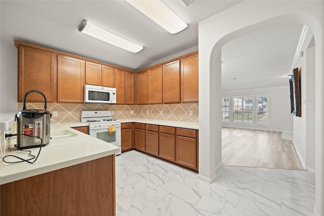 kitchen featuring marble finish floor, white appliances, light countertops, and brown cabinets