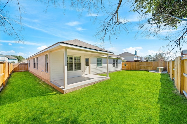 rear view of property featuring a patio area, a fenced backyard, and a yard