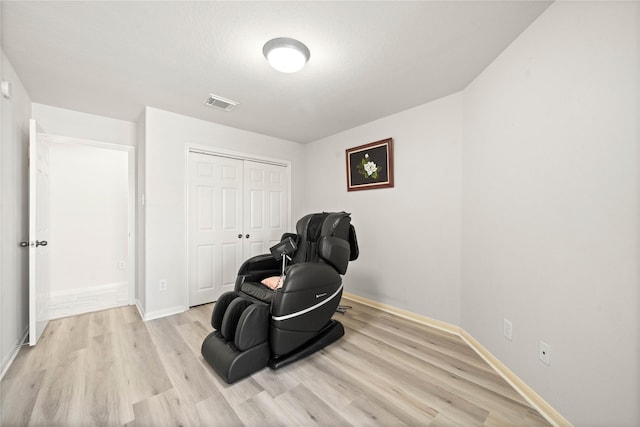 sitting room featuring light wood-type flooring, baseboards, and visible vents