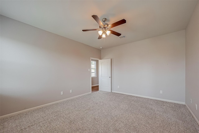 unfurnished room featuring a ceiling fan, carpet, visible vents, and baseboards