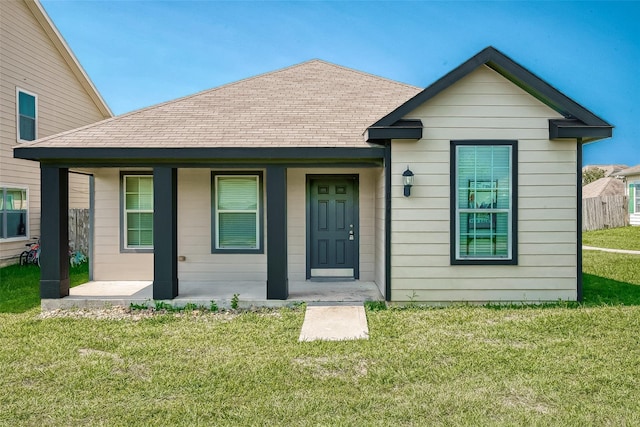 bungalow featuring a shingled roof and a front lawn