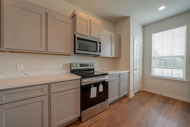 kitchen featuring appliances with stainless steel finishes, a healthy amount of sunlight, and gray cabinetry