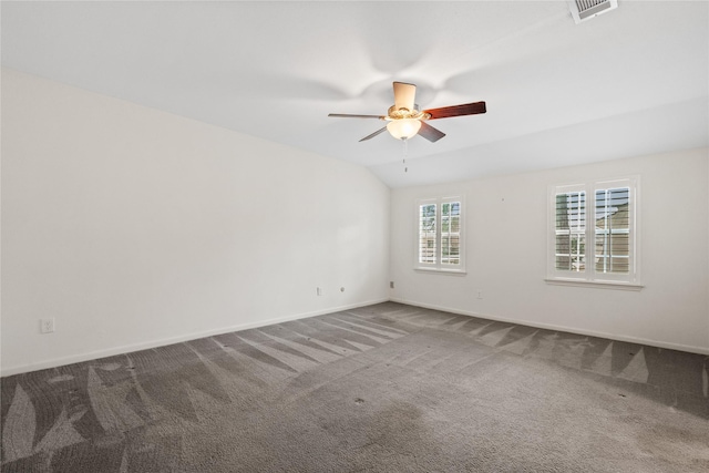 spare room featuring carpet floors, visible vents, vaulted ceiling, ceiling fan, and baseboards