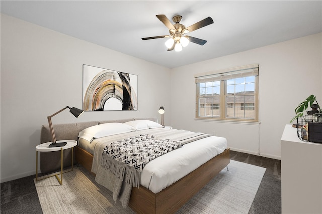 bedroom featuring ceiling fan, baseboards, and dark colored carpet