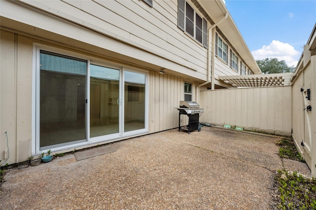 view of patio with area for grilling and fence