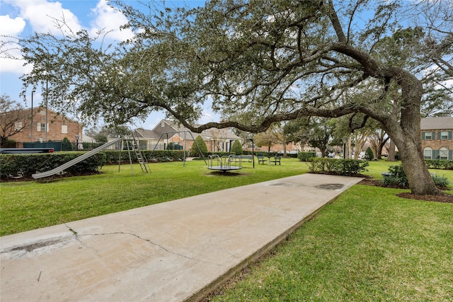 view of home's community featuring playground community and a yard