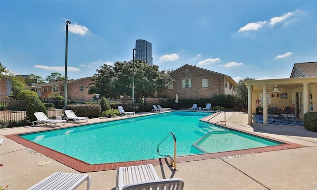 pool featuring a residential view, a patio, and fence