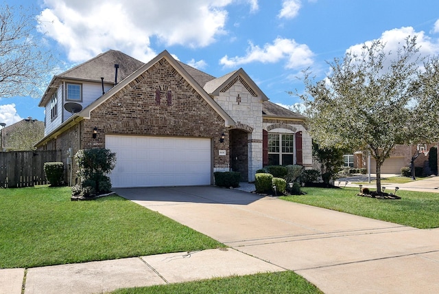 french country home featuring a front yard, concrete driveway, brick siding, and fence