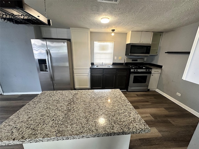 kitchen featuring dark wood-style floors, white cabinetry, appliances with stainless steel finishes, and a sink