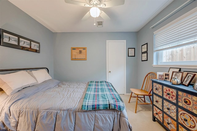 bedroom featuring a ceiling fan, visible vents, and light carpet