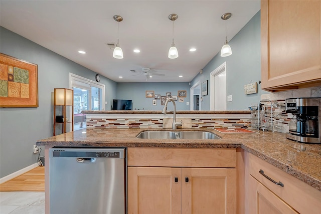 kitchen with decorative backsplash, light brown cabinets, dishwasher, and a sink